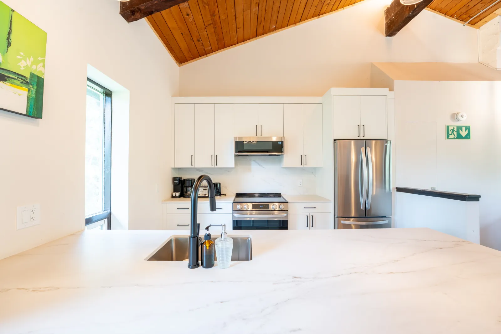 The 44L gallery: white kitchen with a marble island and stainless appliances