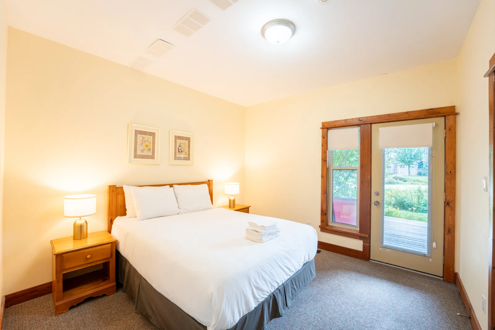 The Aurora gallery: king bed facing the garden door and framed prints