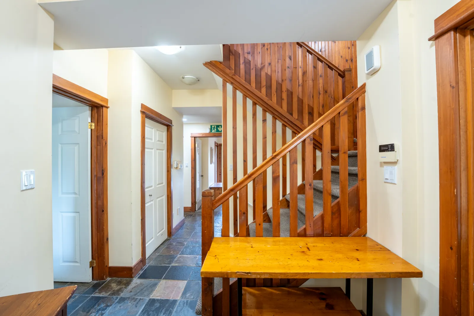 The Aurora gallery: slate-floored entry hall with the timber staircase