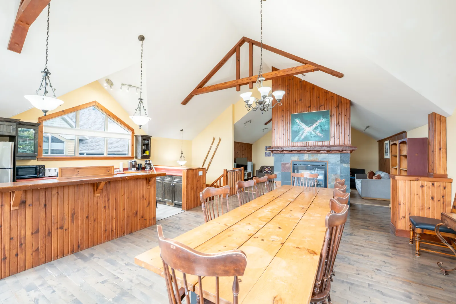 The Aurora gallery: great room from the kitchen: dining table and stone fireplace
