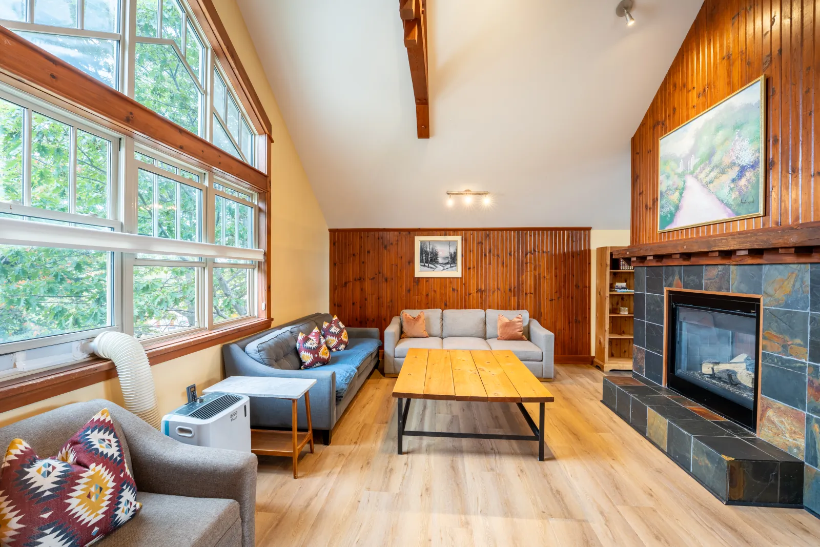 Sofas and wood coffee table beside the slate fireplace at The Aurora, Blue Mountain – Multi-Week Ski Programme Stays, Blue Mountain Ontario