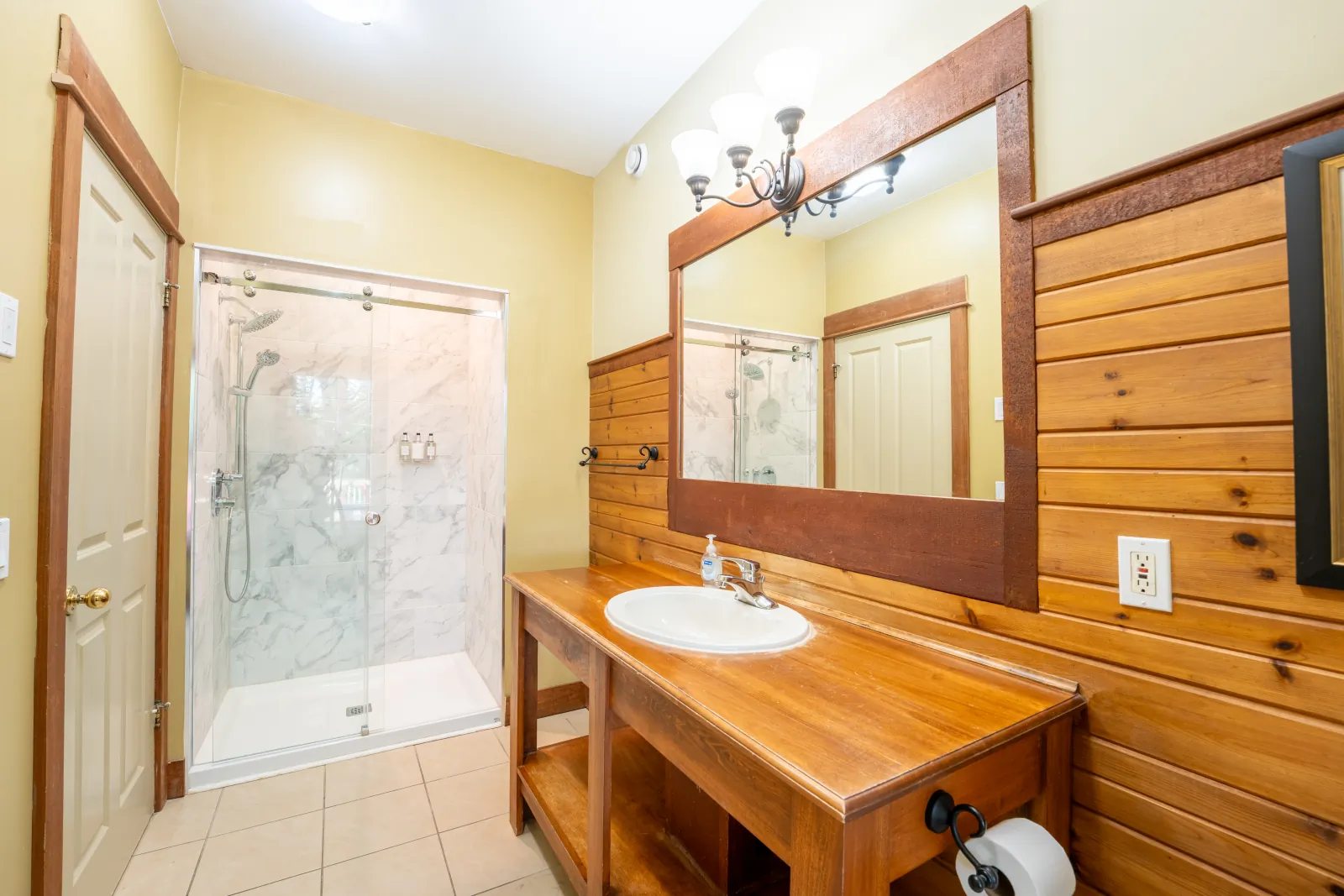 The Omega gallery: wood-panelled bathroom with a vanity and glass shower