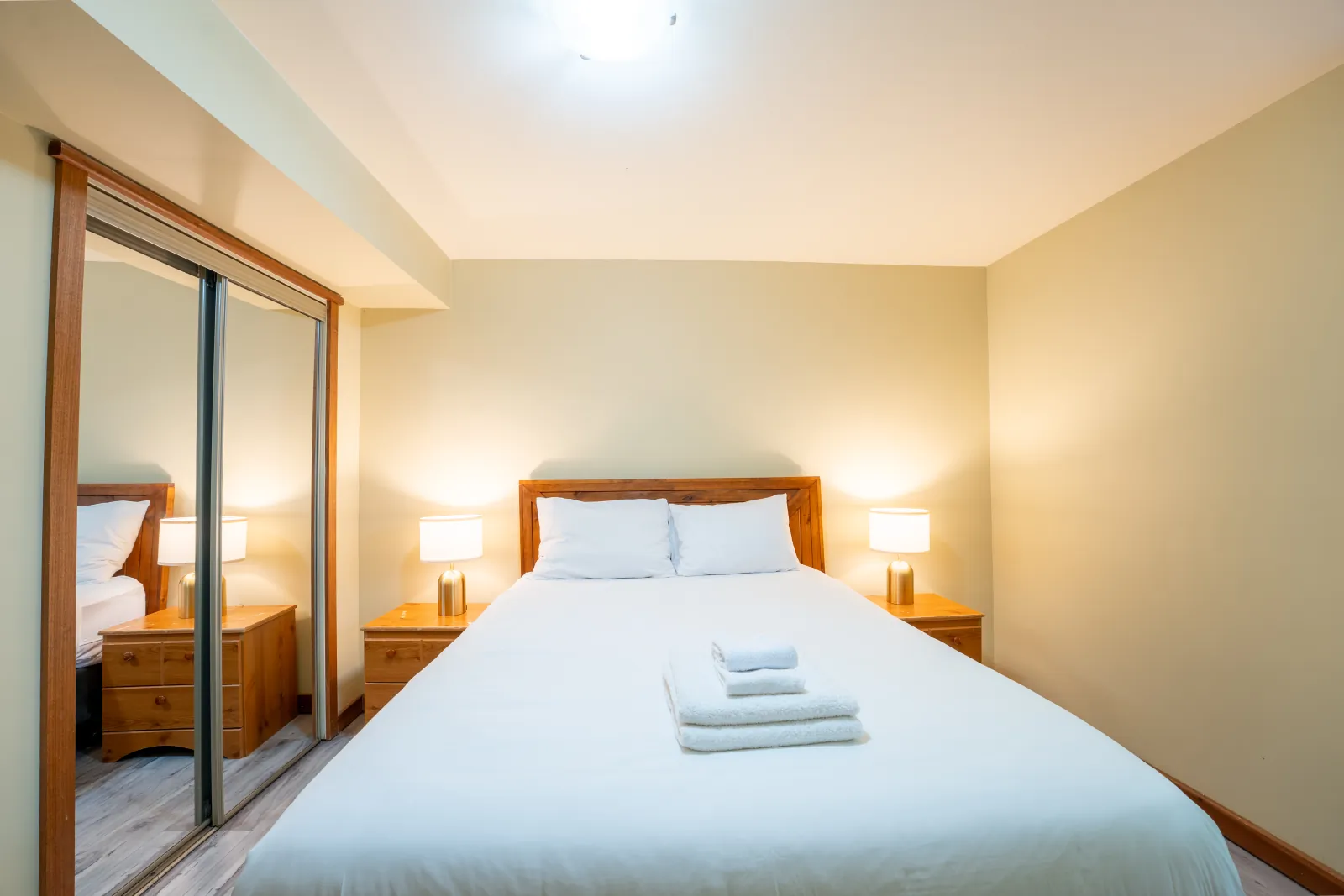 The Omega gallery: queen bed beside a mirrored closet