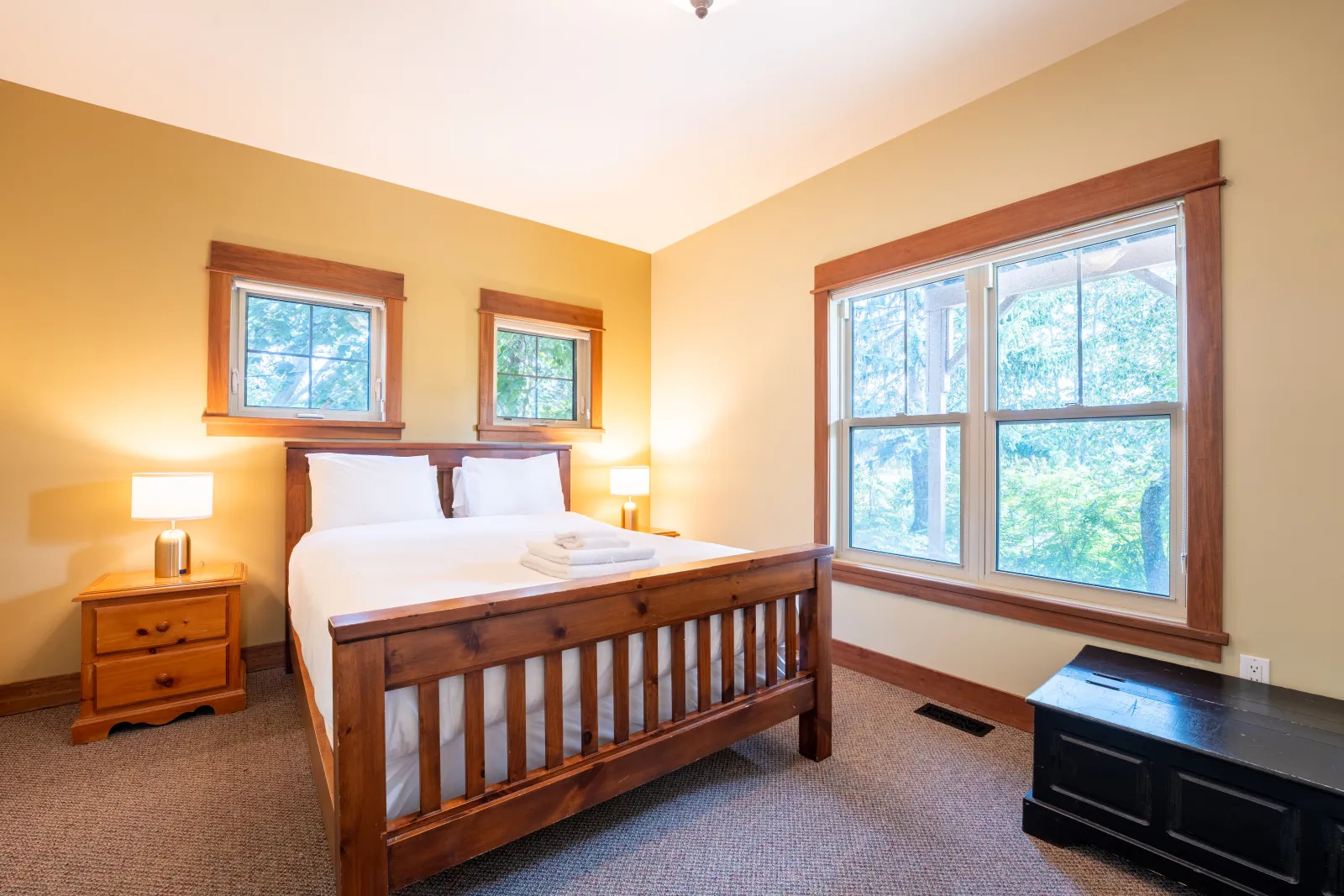 The Omega gallery: queen bedroom with a slatted wood bed and a bench