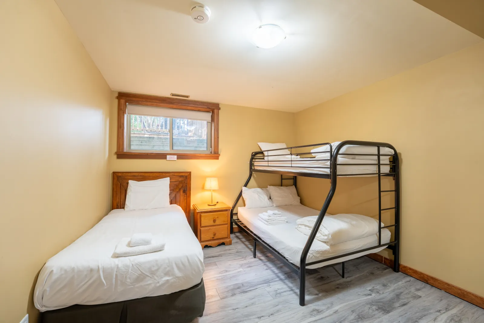 The Omega gallery: bunk room with a single bed and a black metal bunk – stay near Wasaga Beach Regional Silver Stick Tournament