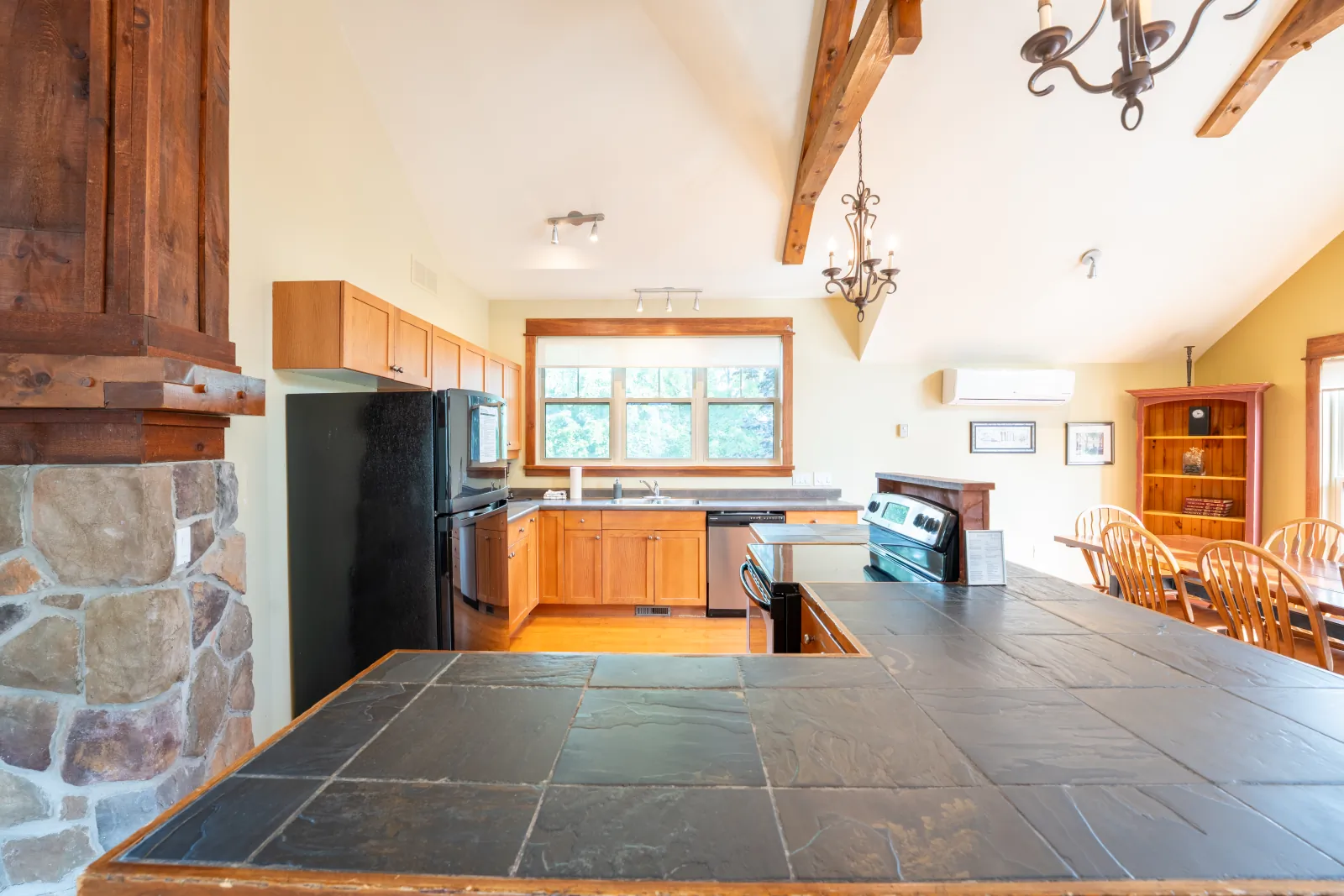 The Omega gallery: kitchen island beside the stone fireplace column
