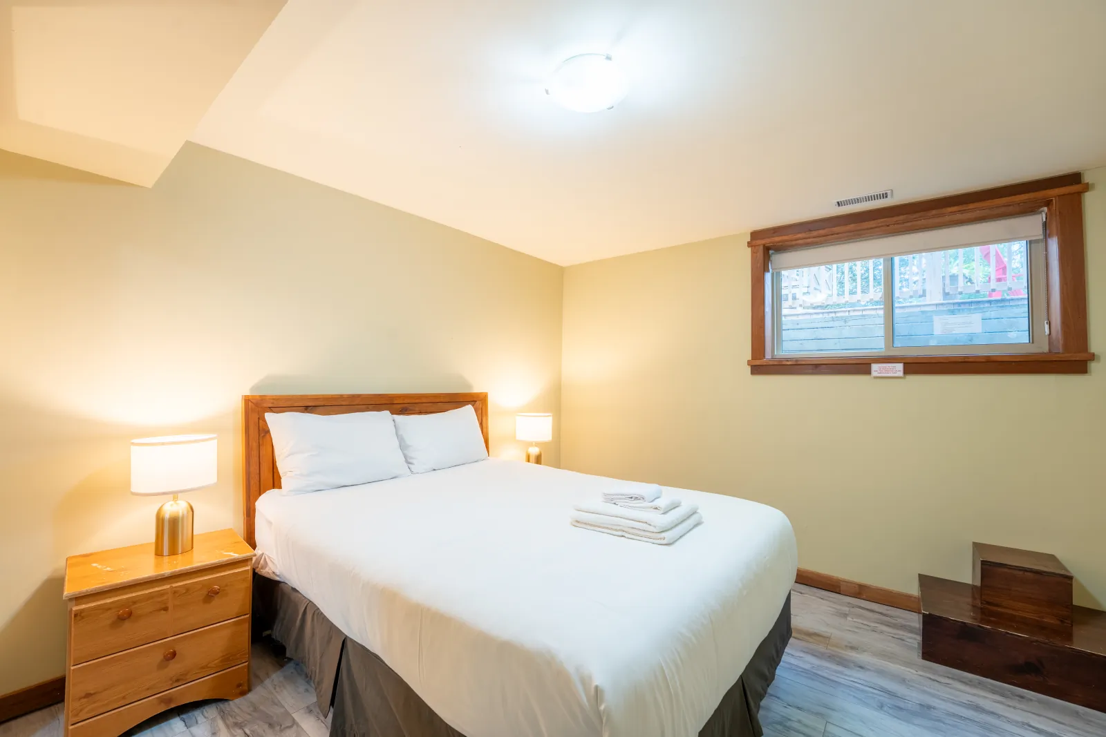 The Omega gallery: lower-level queen bedroom with a small window