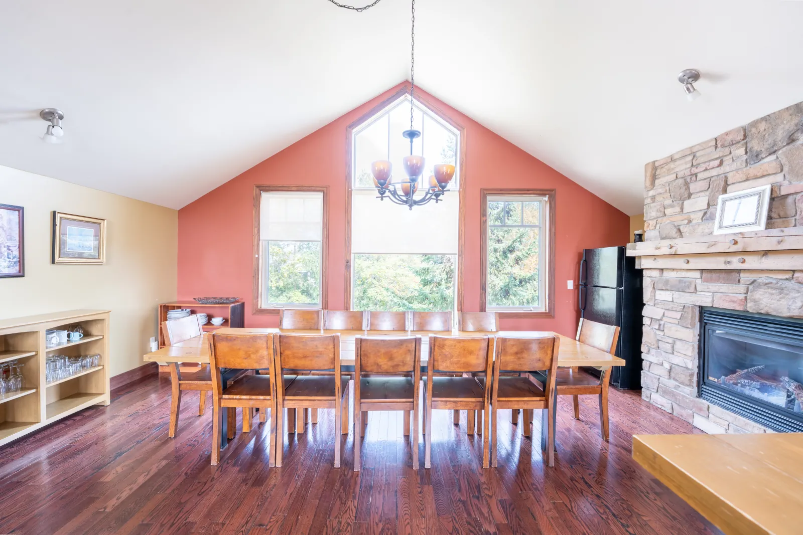 The Stella gallery: dining table beside the stone fireplace