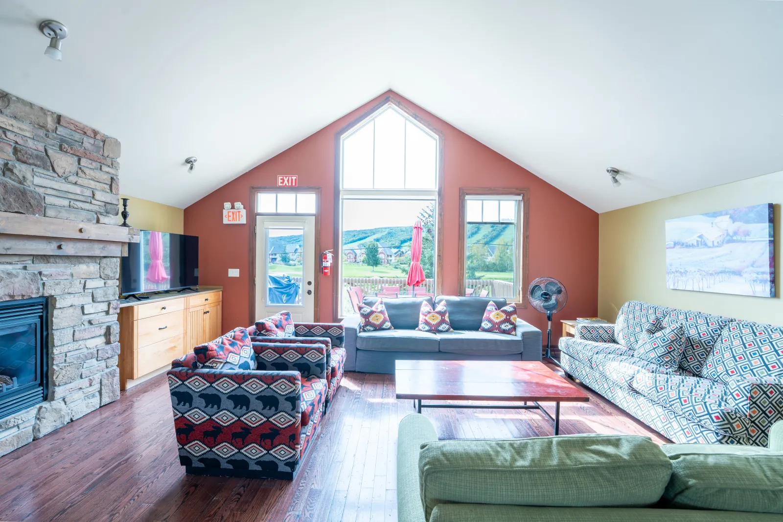The Stella gallery: sofas beside the stone fireplace and red accent wall