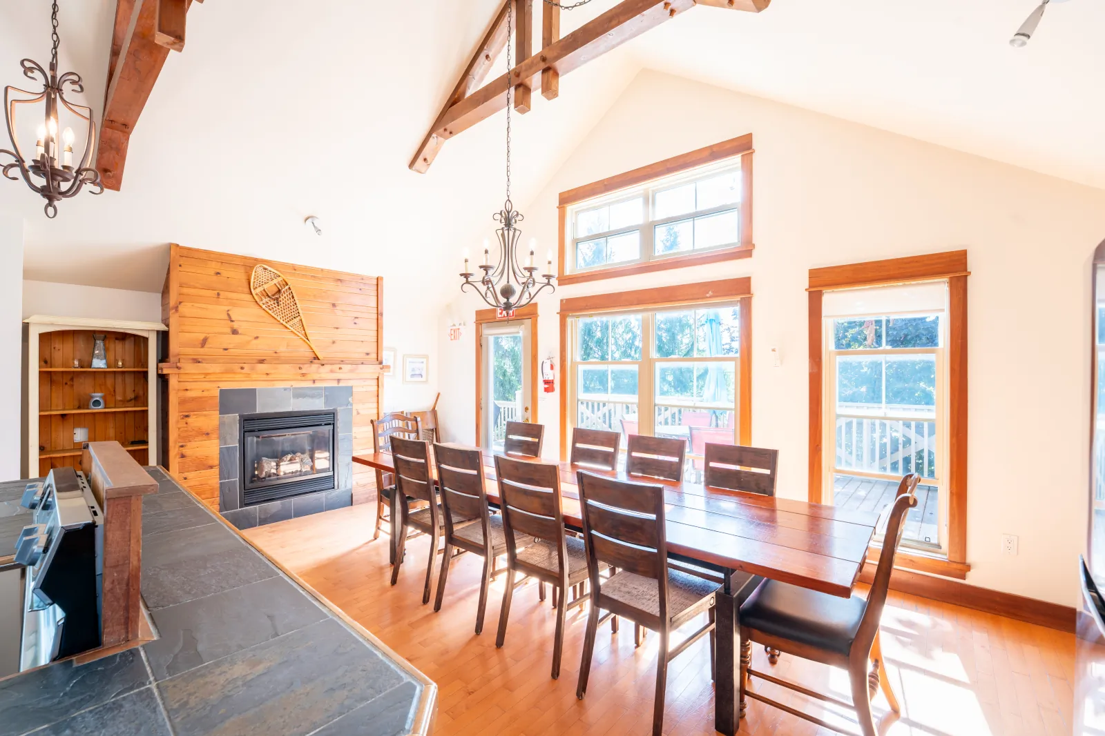 The Vega gallery: dining table beside the fireplace and tall windows