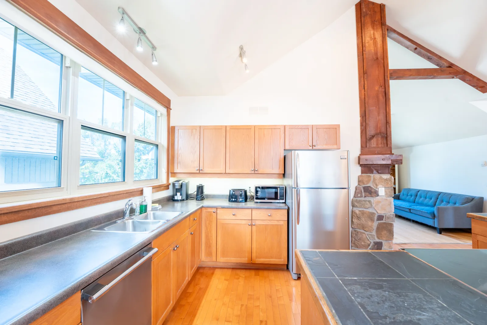 The Vega gallery: kitchen with stainless appliances and a slate island – stay near Steakilicious Bonspiel
