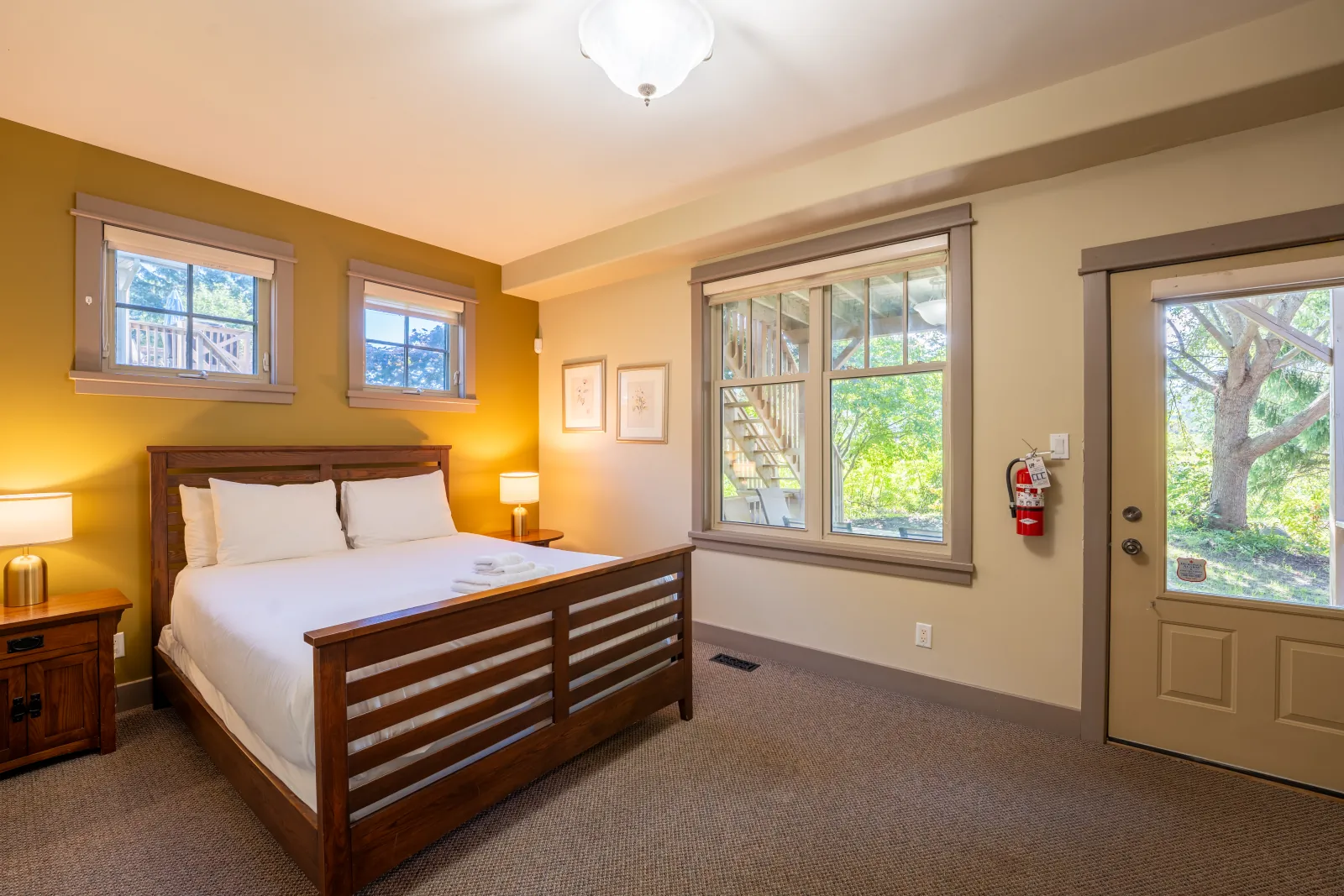 The Vista gallery: queen bedroom with a wood bed, corner windows and a garden door