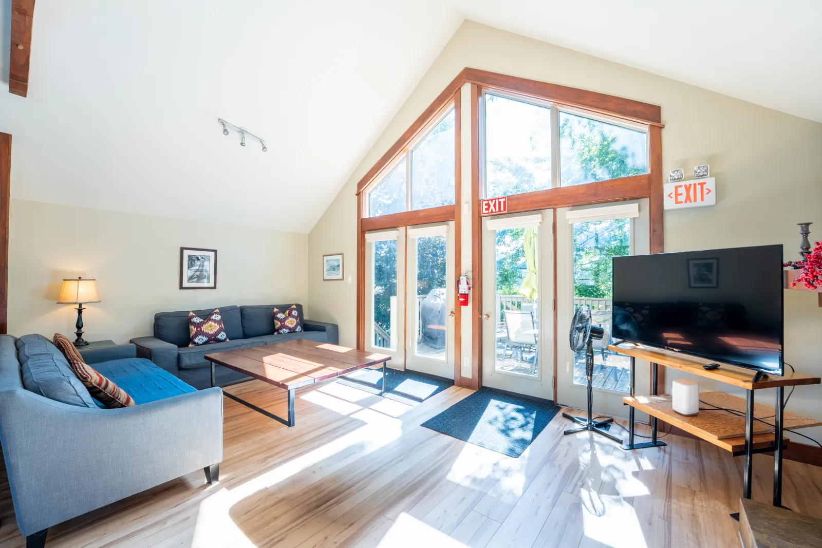 The Vista gallery: blue sofa and TV beneath the tall peaked windows